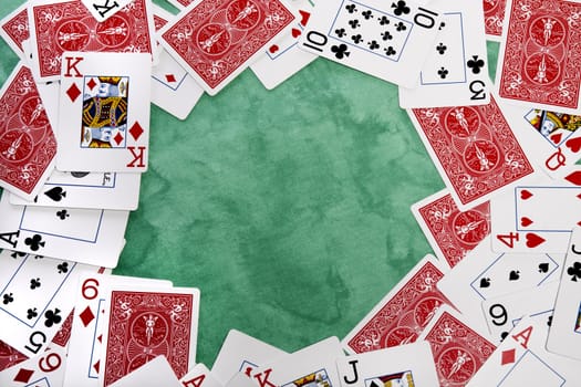 Close up view of a bunch cards spread on a green cloth table.