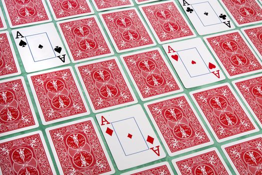 Close up view of a bunch of flipped playing cards spread on a green cloth table.