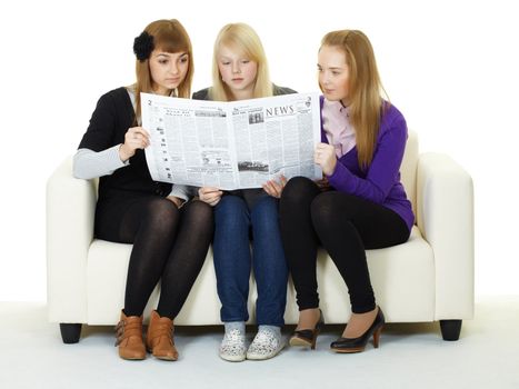 Young girl reading a newspaper sitting on the couch