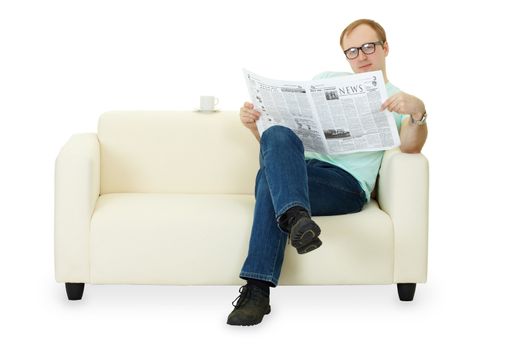 A man reading a newspaper at home sitting on the sofa