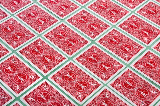 Close up view of a bunch of flipped playing cards spread on a green cloth table.