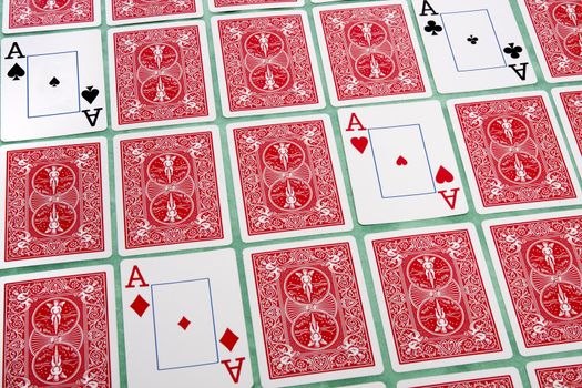 Close up view of a bunch of flipped playing cards spread on a green cloth table.