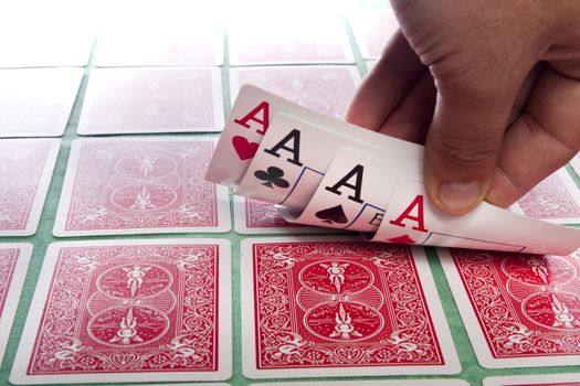 Close up view of a bunch of flipped playing cards spread on a green cloth table.