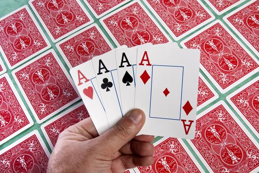 Close up view of a bunch of flipped playing cards spread on a green cloth table.