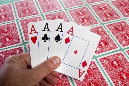 Close up view of a bunch of flipped playing cards spread on a green cloth table.