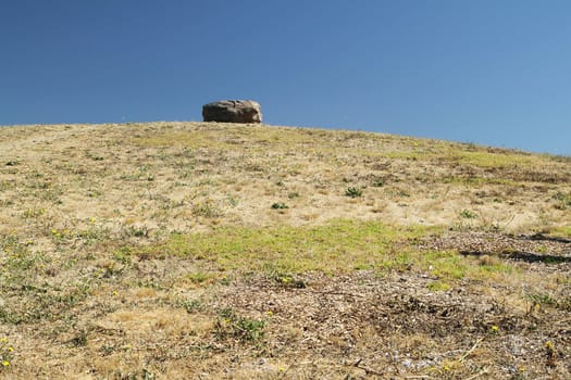 A rock on the hill on sunny day