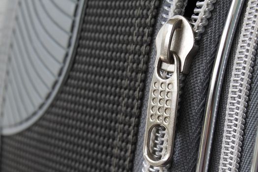 A zipper on grey suitcase closeup photo