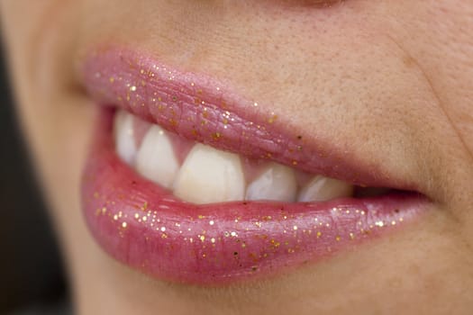 Close up view of some pink lips smiling.