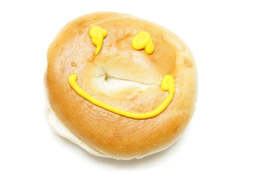 A bagel with mustard eyes and smile isolated on white background