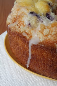 Blueberry cake on yellow plate with white napkin