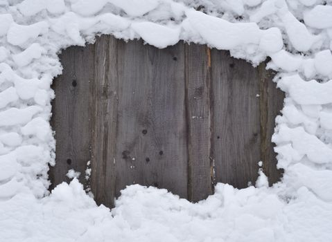 Winter natural photo: snow frozen to a wooden fence