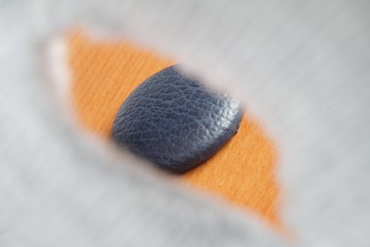 View of button through the buttonhole in the shape of eye