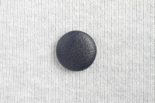 Blue button at the center on white cloth