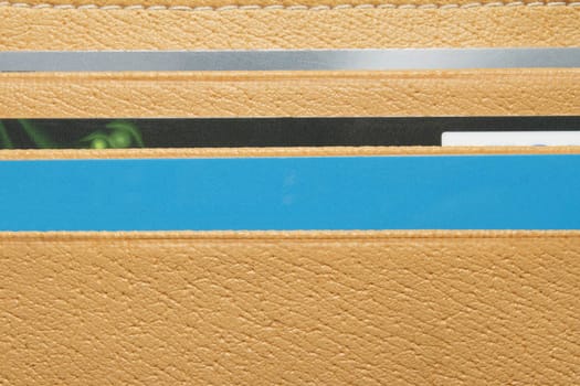 Opened yellow wallet with three colored plastic cards inside