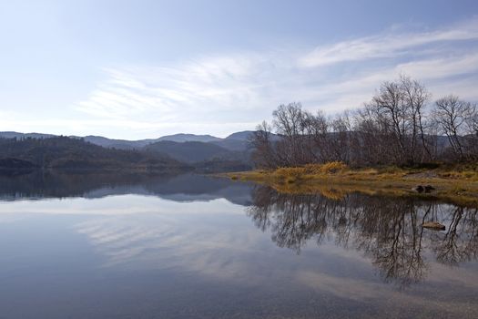 Peacefull lake, bare trees and autumn colors at Haukeli, Norway