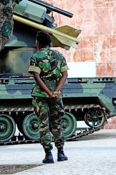 Black soldier woman standing next to an armored missile vehicle.