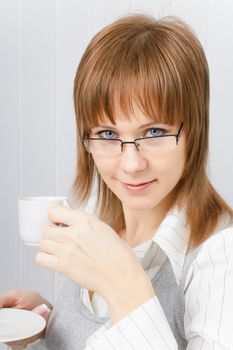 attractive girl in glasses with a cup of coffee in hand
