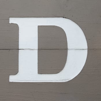 White carved letter d on the wooden board