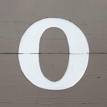 White carved letter o on the wooden board