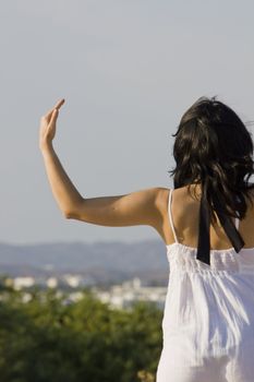 Young woman with white dress surrounded practicing yoga.