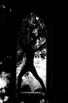 View of the figure of a young woman in silhouette over an arc.