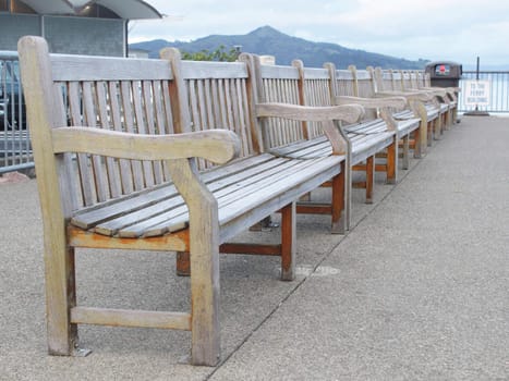 Row of wooden benches on the wharf in the evening light