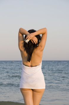 young woman with flower enjoys the sea.