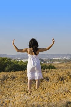 Young woman with white dress surrounded practicing yoga.