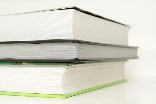 A stack of three books, closeup photo