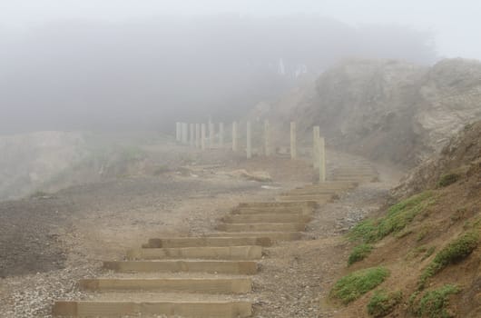 Wooden stairs among rocks in foggy day