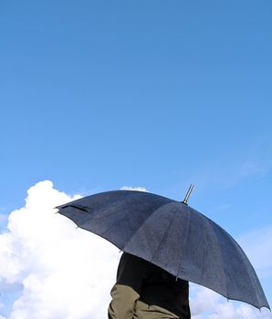 young woman with umbrella watching the clouds.