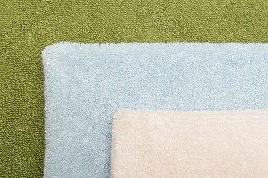 Closeup photo of three bath towels of differen colors