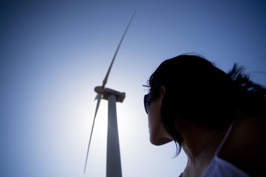 View of a young girl watching a windmill.