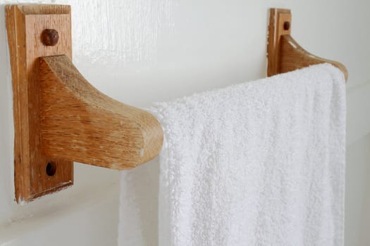 Wooden towel hanger with white towel hanging