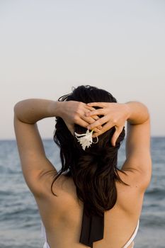 young woman with flower enjoys the sea.