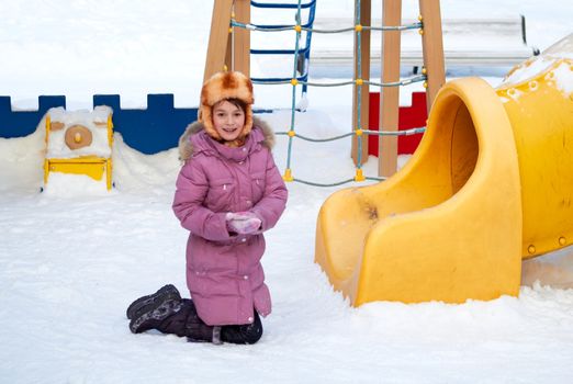 The girl at a childrens play area in winter