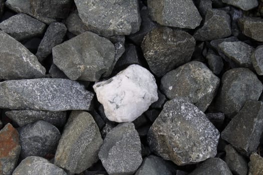 Single white stone among grey ones