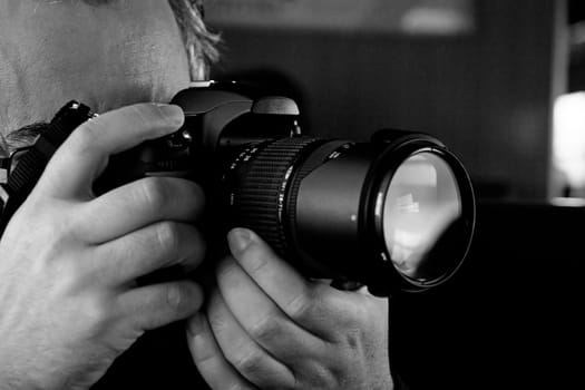 Close up view of a photographer taking a picture with a digital camera.