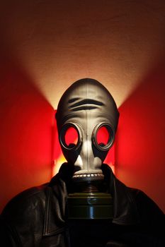 Man wearing gas mask on red background with lighting effect