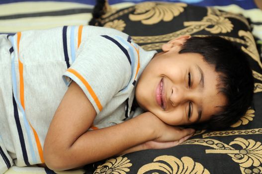 An handsome Indian kid sleeping very happily

