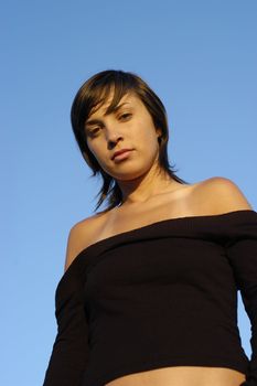 young woman posing against the blue sky