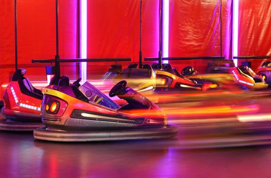Bumper cars in motion in amusement park