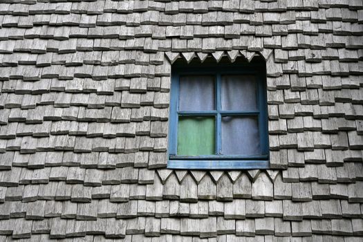 Colored window on a ancient wooden roof