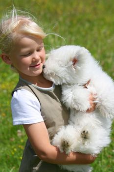 Happy girl bearing a puppy in her arms