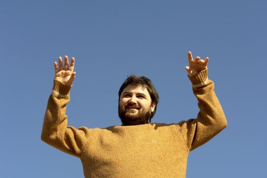 Young man enjoying the sun, copy space in the blue sky