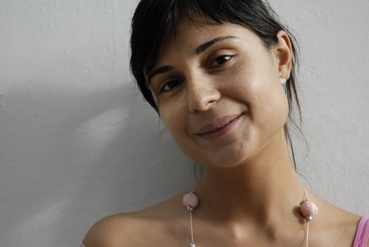 close portrait of a young woman in a white wall