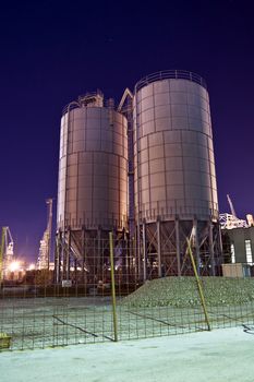 Construction site with silos by night