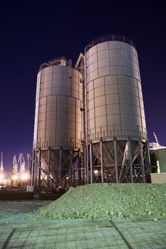 Construction site with silos by night