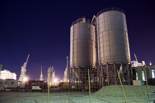 Construction site with silos by night