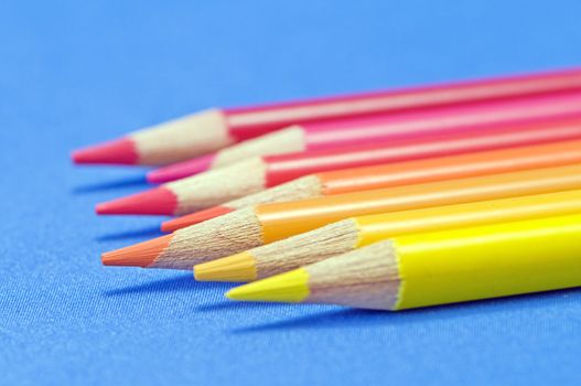 Yellow to red pencils macro on blue